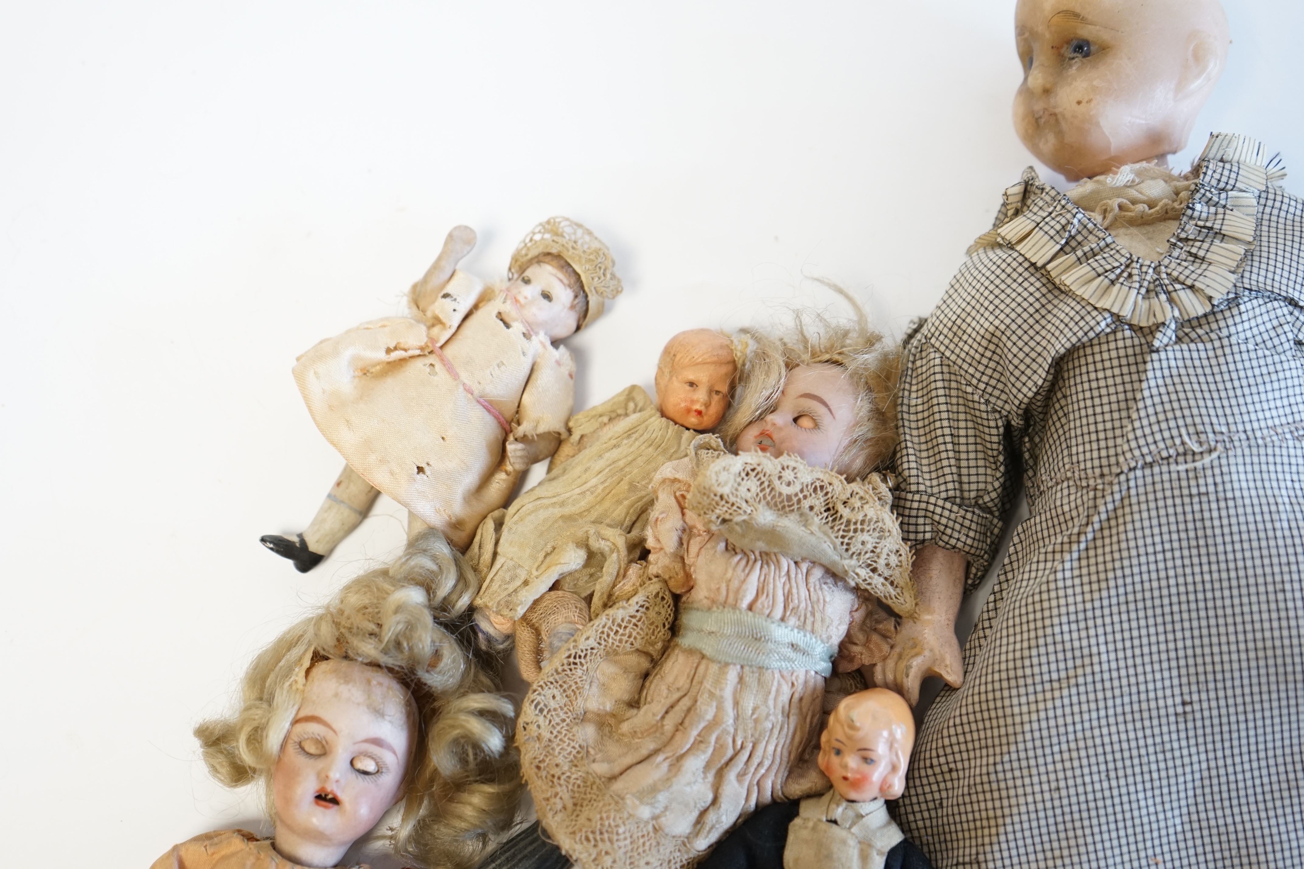 Eleven doll's house dolls, 19th and early 20th century, including two Kammer & Reinhardt bisque jointed dolls and a wax over composition doll in original clothes (12). Condition - fair